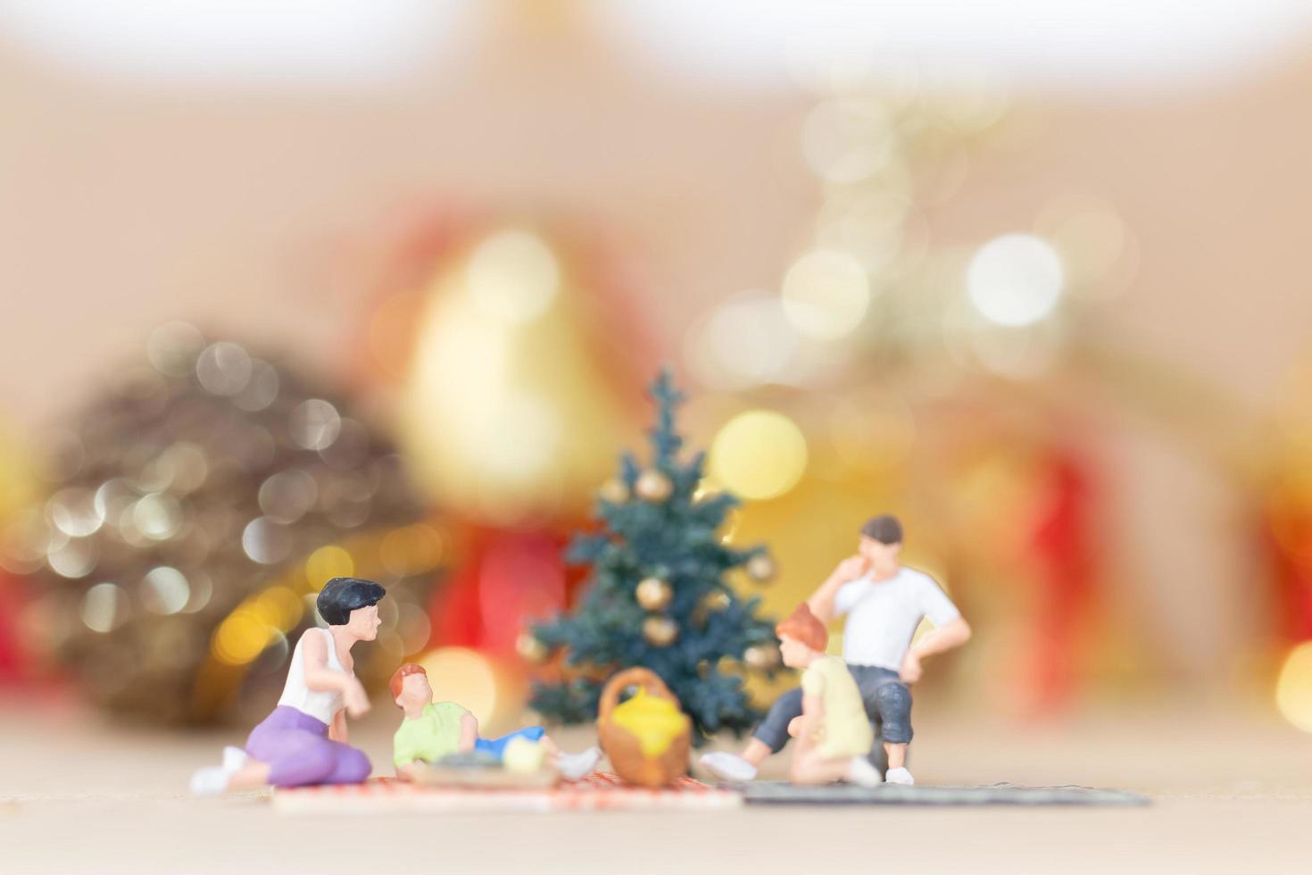 miniatuur gelukkige familie die kerstmis, kerstmis en gelukkig nieuwjaarconcept viert foto