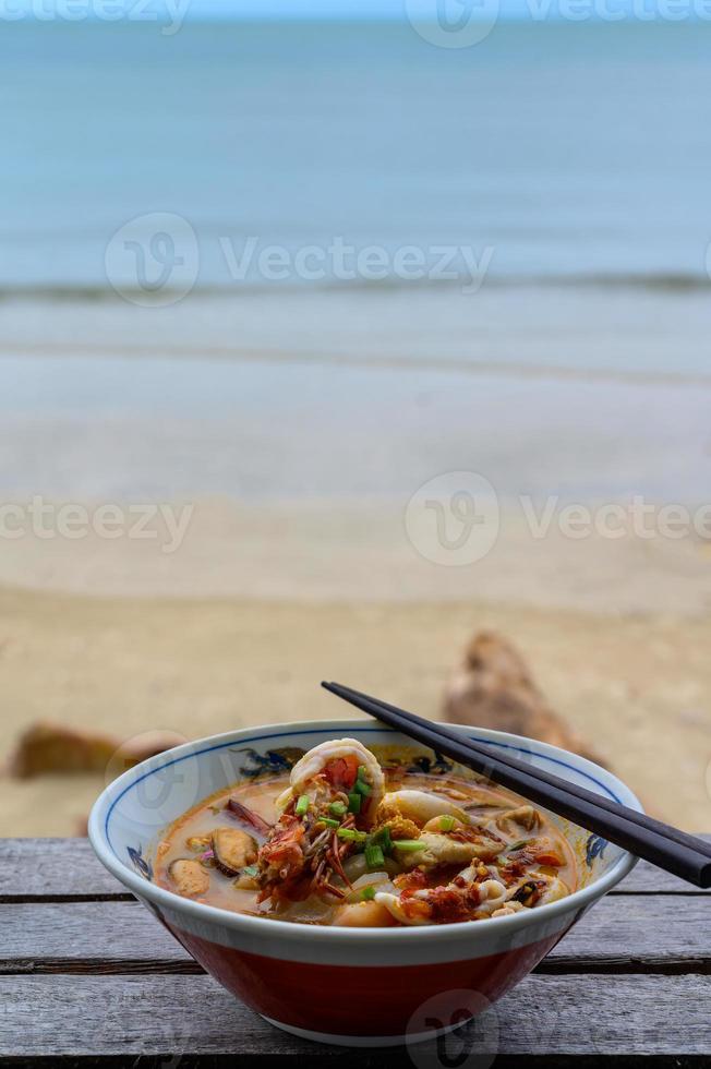 pittige tom yum-soep op het strand foto