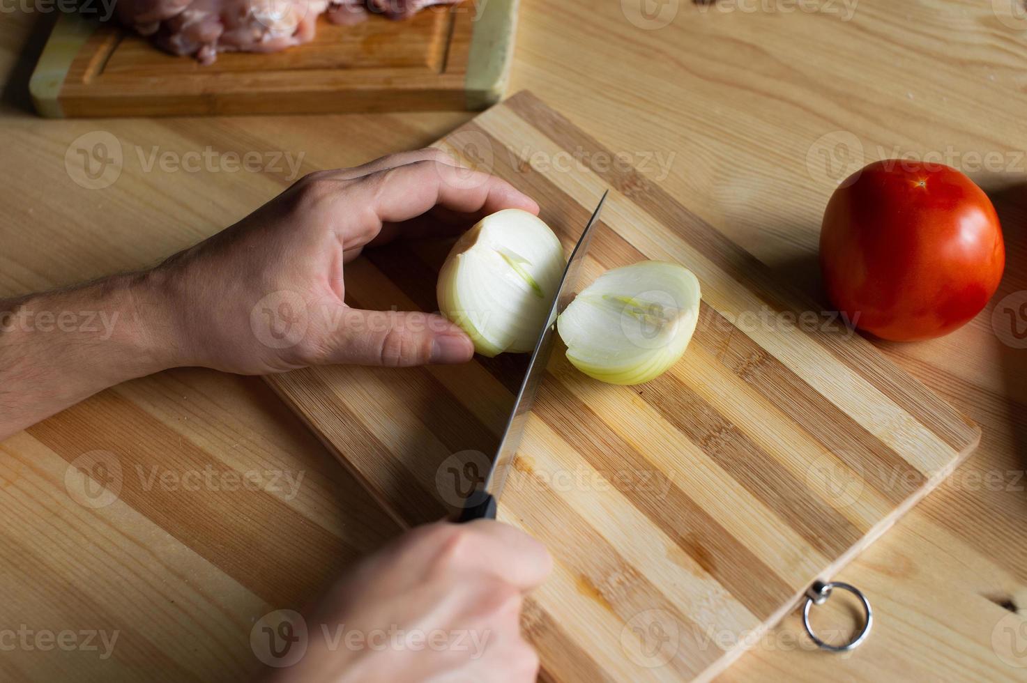 Mannen handen besnoeiing uien Aan een houten bord foto