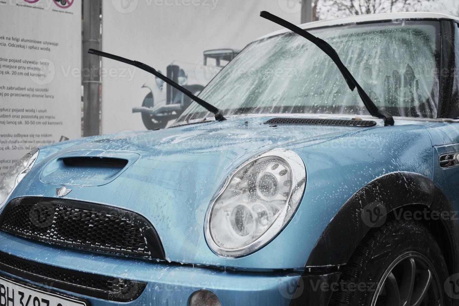 hand- wassen met zeep, roze schuim Aan de lichaam. auto het wassen met hoog druk water. wassen mini kuiper. foto