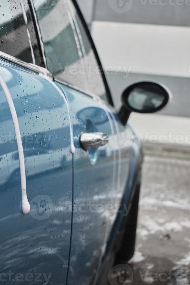 hand- wassen met zeep, roze schuim Aan de lichaam. auto het wassen met hoog druk water. wassen mini kuiper. foto