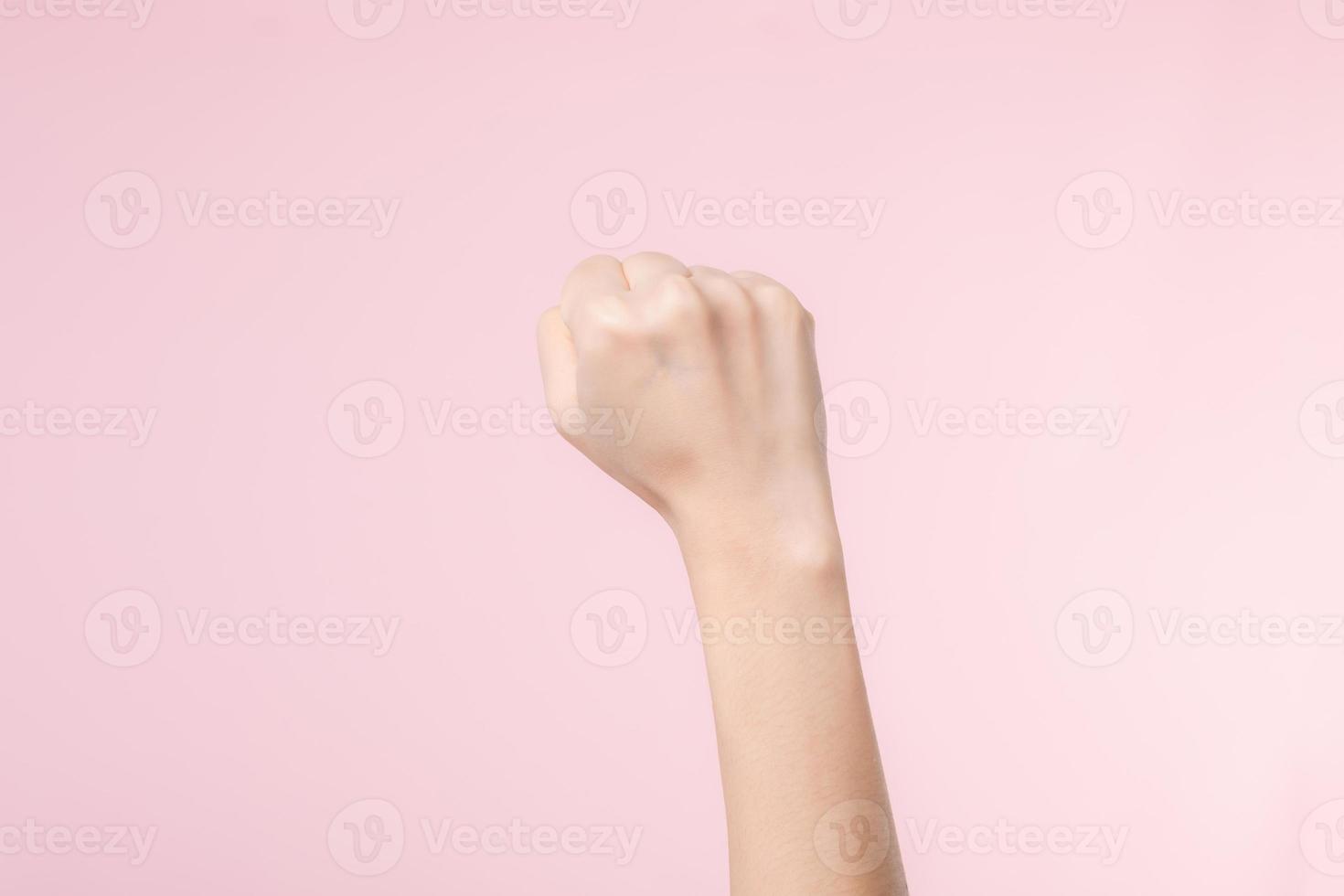 vrouw vuist strijd voor menselijk rechten en feministisch met roze pastel achtergrond. Dames machtiging, gelijkwaardigheid, sterkte en moed concept foto