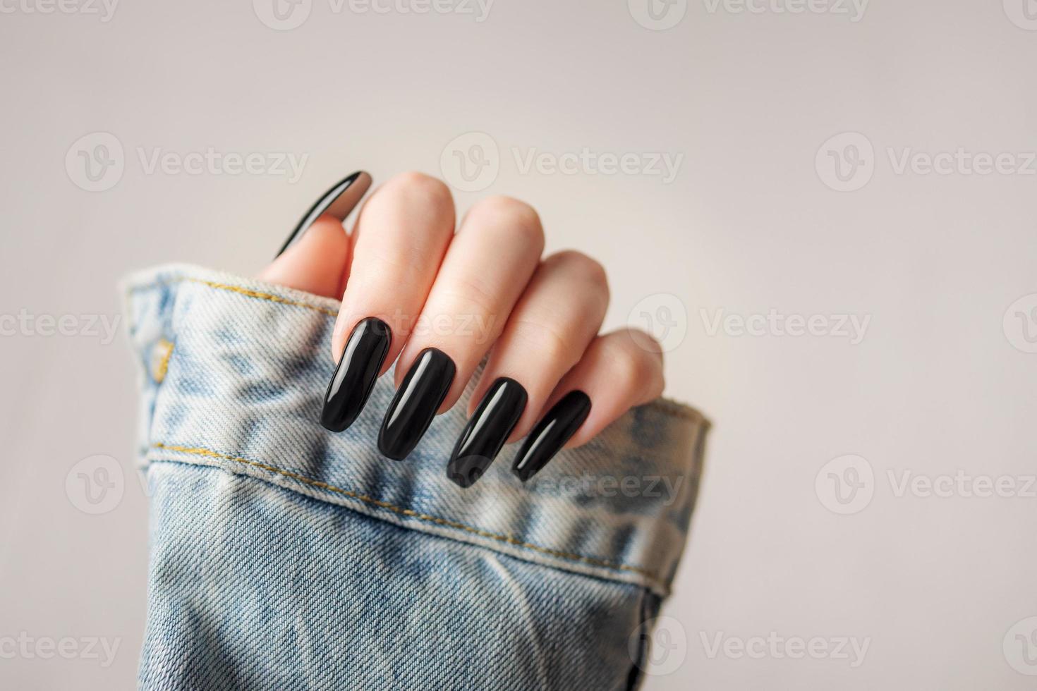 hand- van een jong meisje met zwart manicure Aan nagels foto