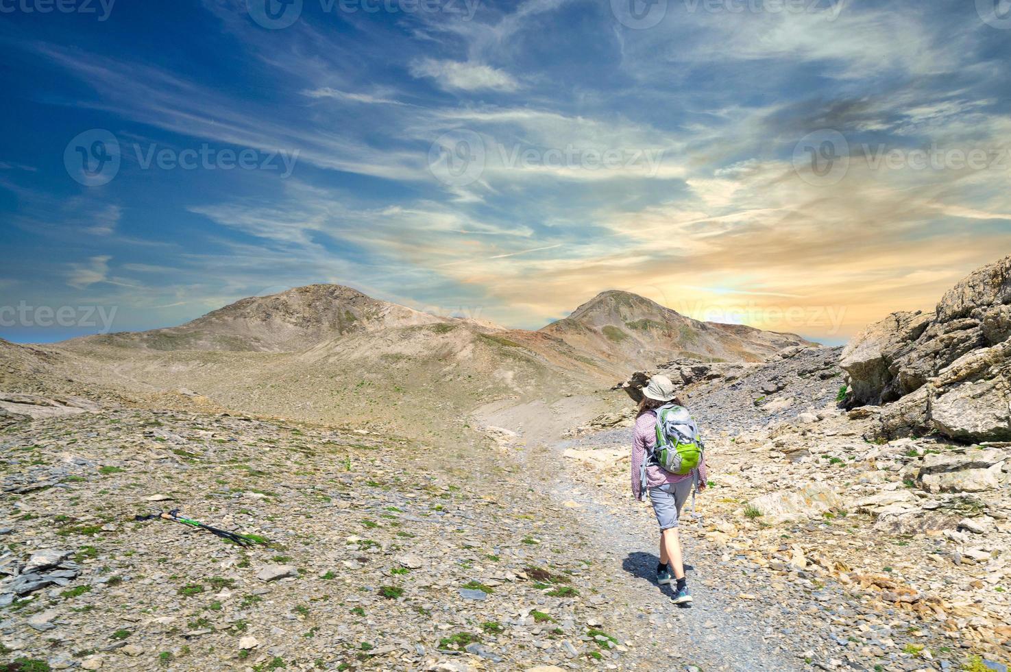 een vrouw wandelaar Aan een hoog berg spoor foto