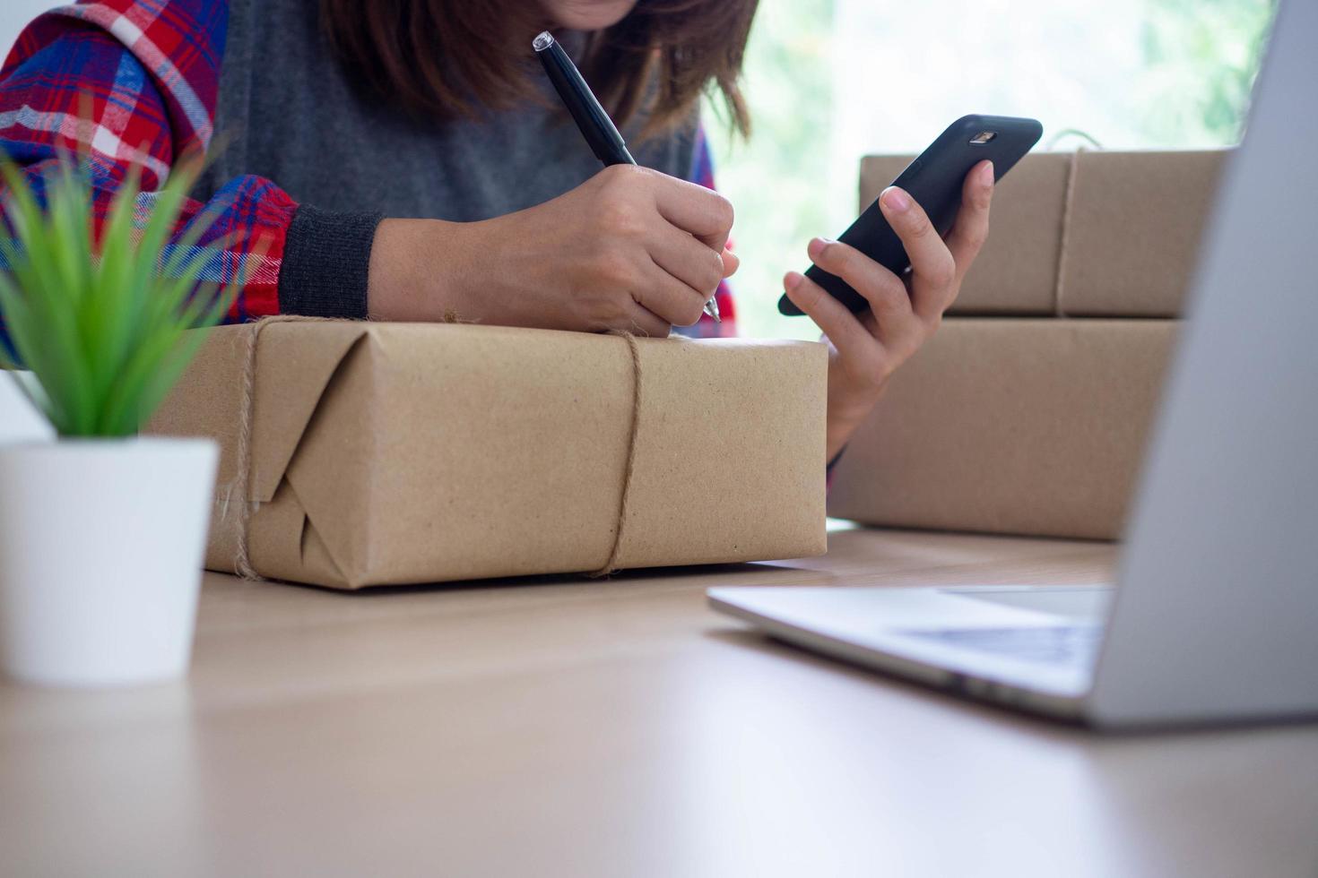 bedrijf Dames babbelen gelukkig met online klanten. en voorbereidingen treffen de doos naar leveren de Product naar online winkelend publiek. mkb bedrijf, klein bedrijf concept foto