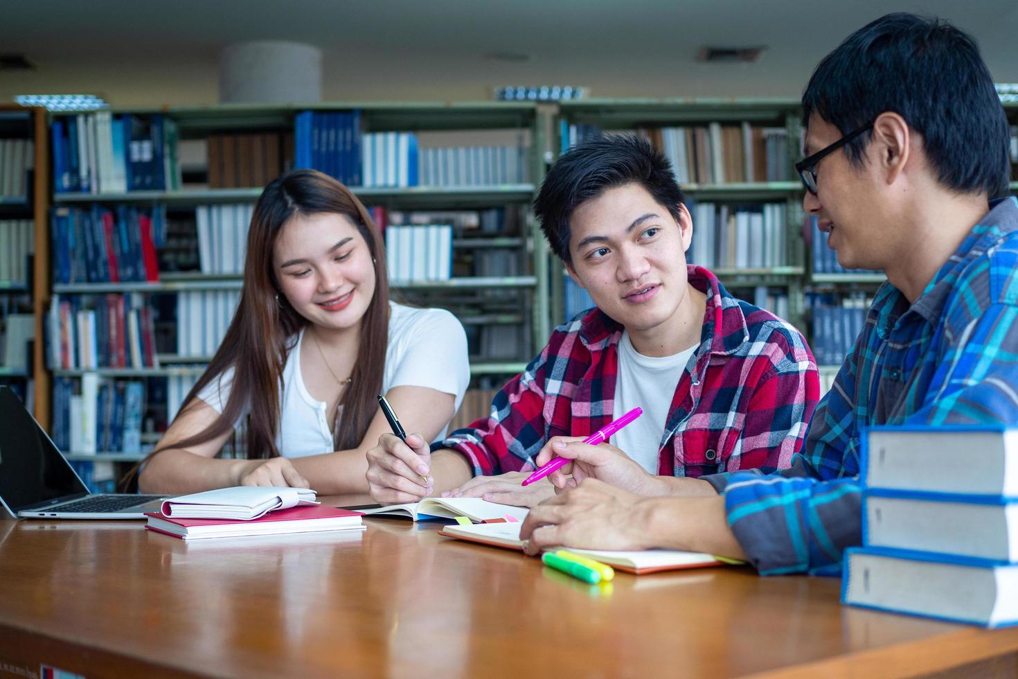 een groep van studenten of Universiteit studenten genieten aan het studeren in de college bibliotheek. foto