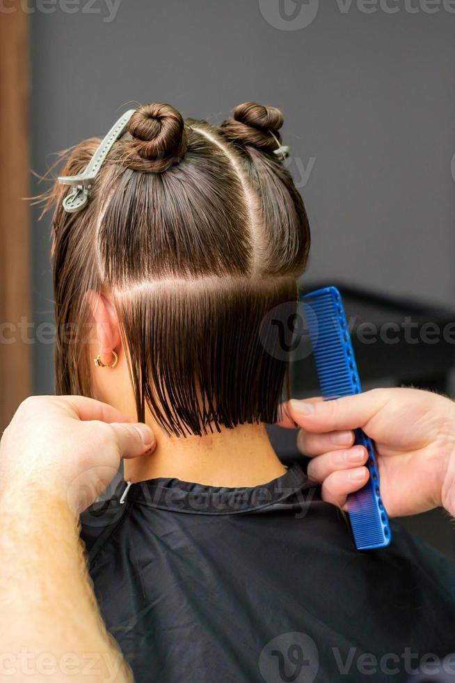 mannetje kapper snijdend haar- van vrouw foto