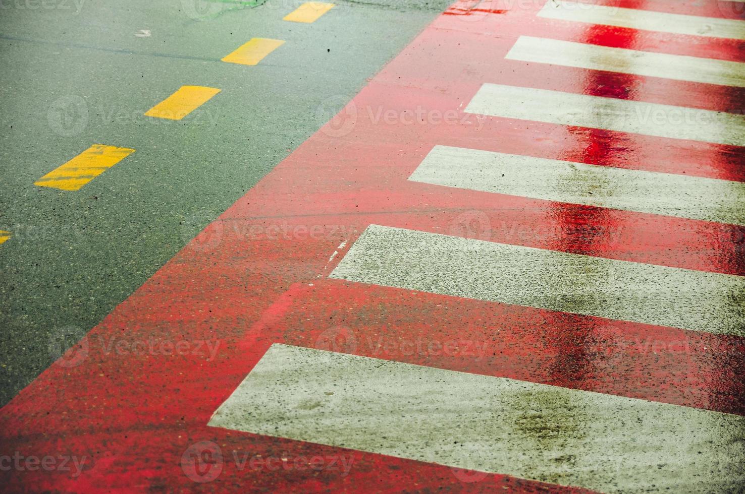 zebra kruispunt teken Aan een nat weg. asfalt weg met zebra kruispunt. foto