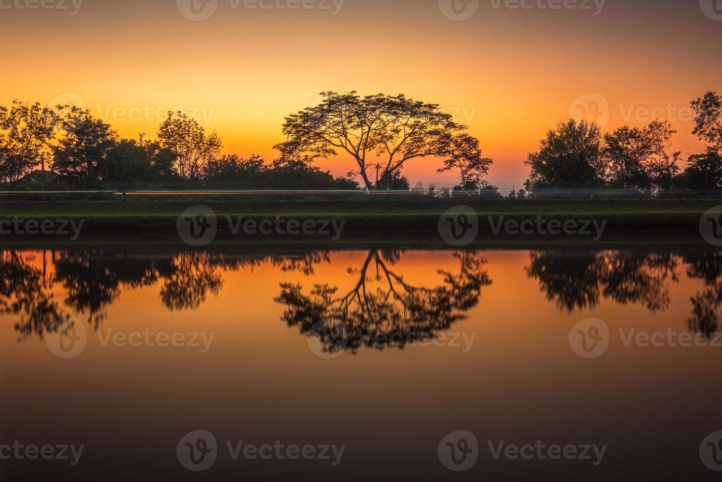bomen door de kanaal Bij zonsondergang, water reflectie foto