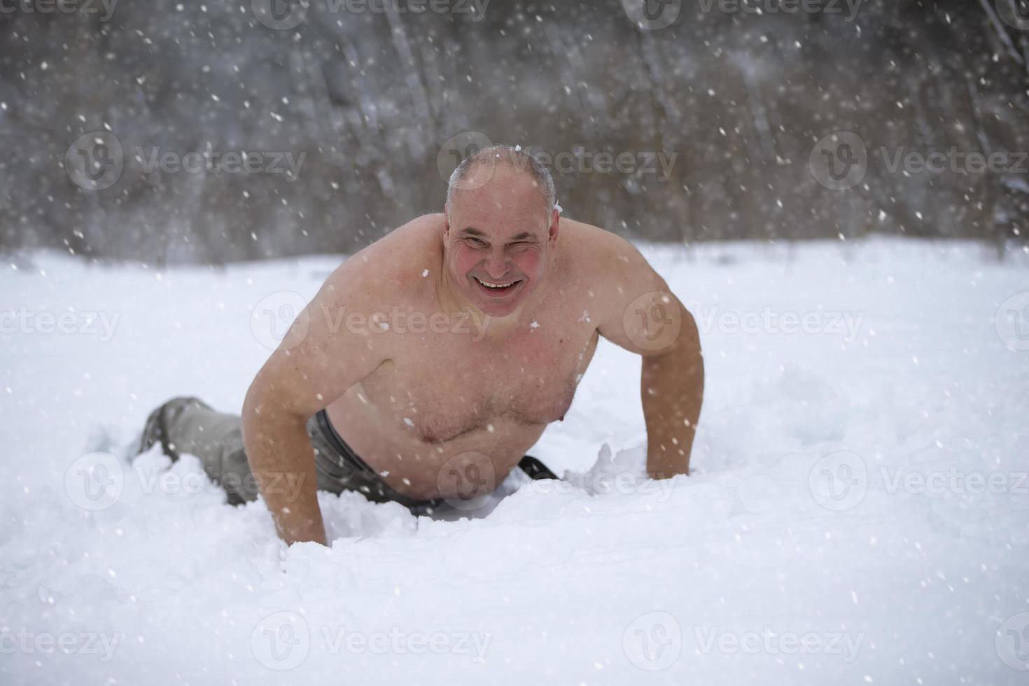 een volwassen Mens is gehard door sneeuw Aan een winter dag. een naakt Mens leugens in de sneeuw. foto