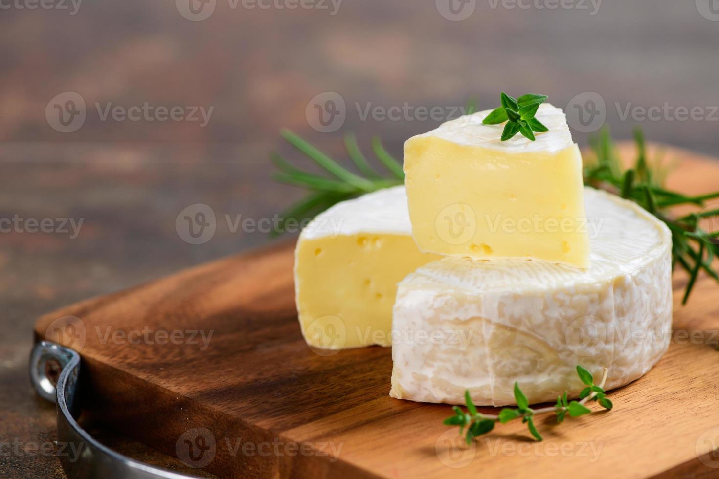 gesneden Camembert kaas met tijm Aan hout bord. foto