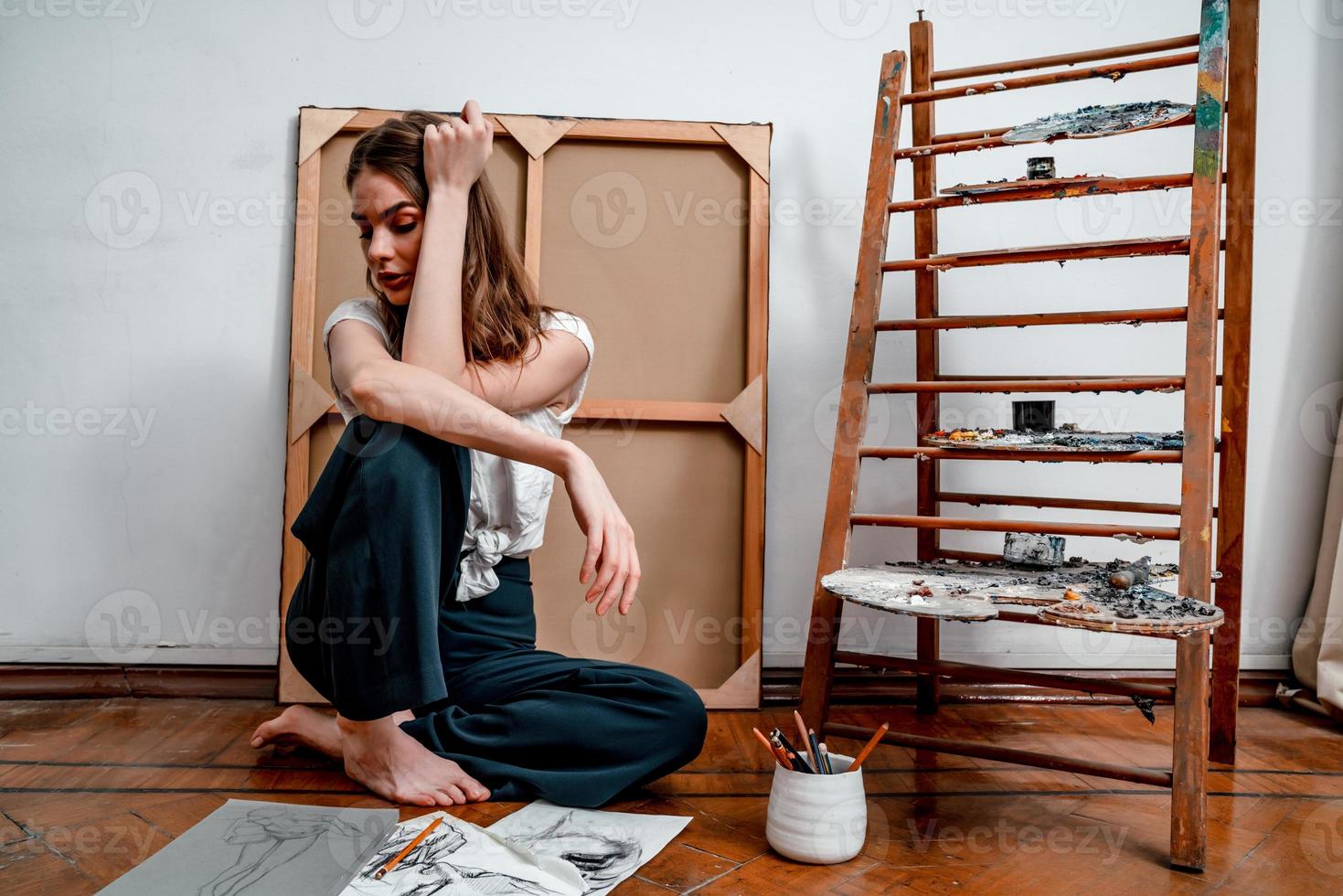 portret van een mooi jong artiest, trekt afbeeldingen in de werkplaats foto