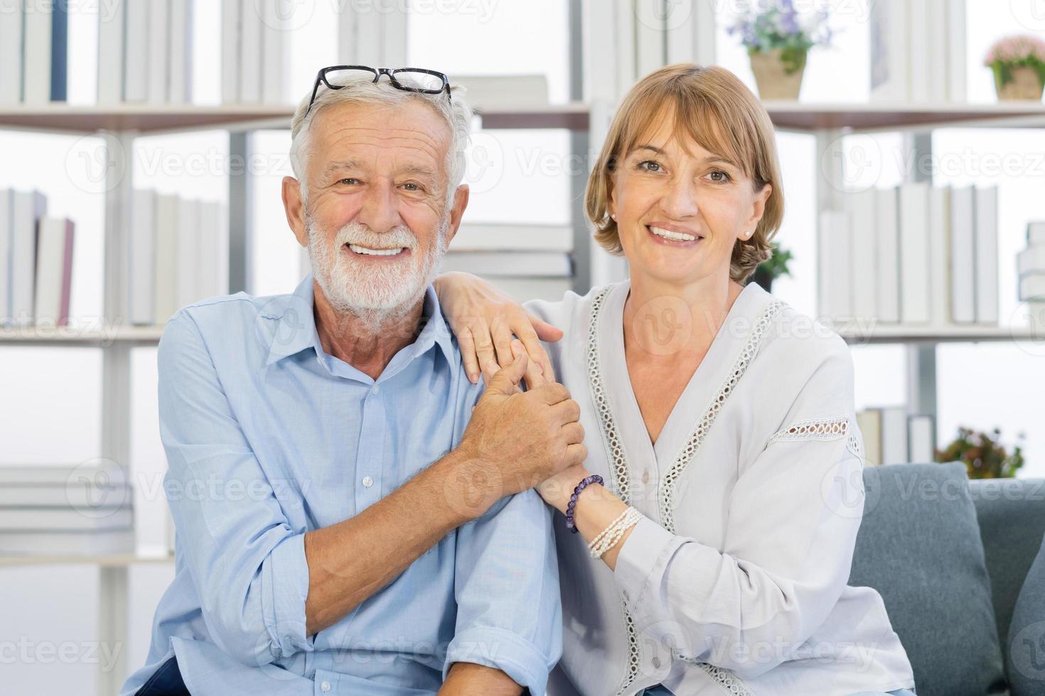 gelukkig minnaar, senior ouder Kaukasisch paar liefde, familie volwassen glimlachen samen, gezicht uitdrukken ontspannen pret terwijl zittend Aan bank, bankstel Bij huis. genoegen van met pensioen, pensioen echtgenoot, vrouw levensstijl. foto