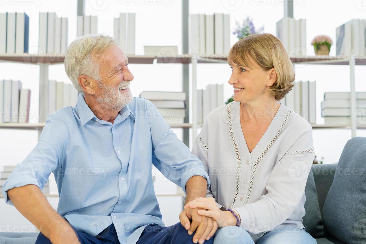 gelukkig minnaar, senior ouder Kaukasisch paar liefde, familie volwassen glimlachen samen, gezicht uitdrukken ontspannen pret terwijl zittend Aan bank, bankstel Bij huis. genoegen van met pensioen, pensioen echtgenoot, vrouw levensstijl. foto