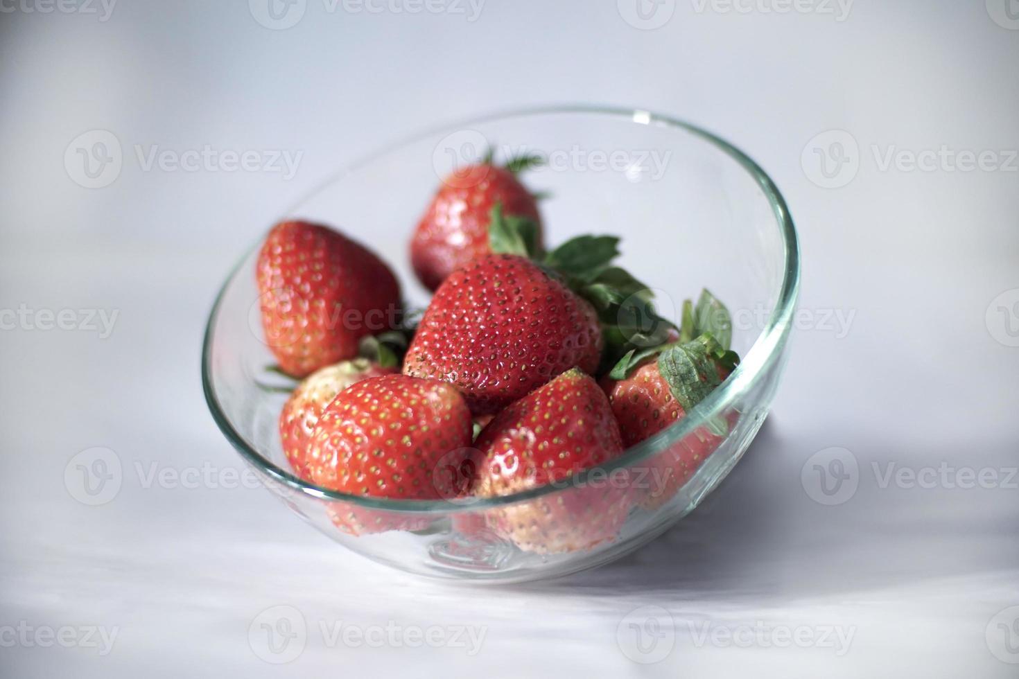 sommige aardbeien in een glas kom foto