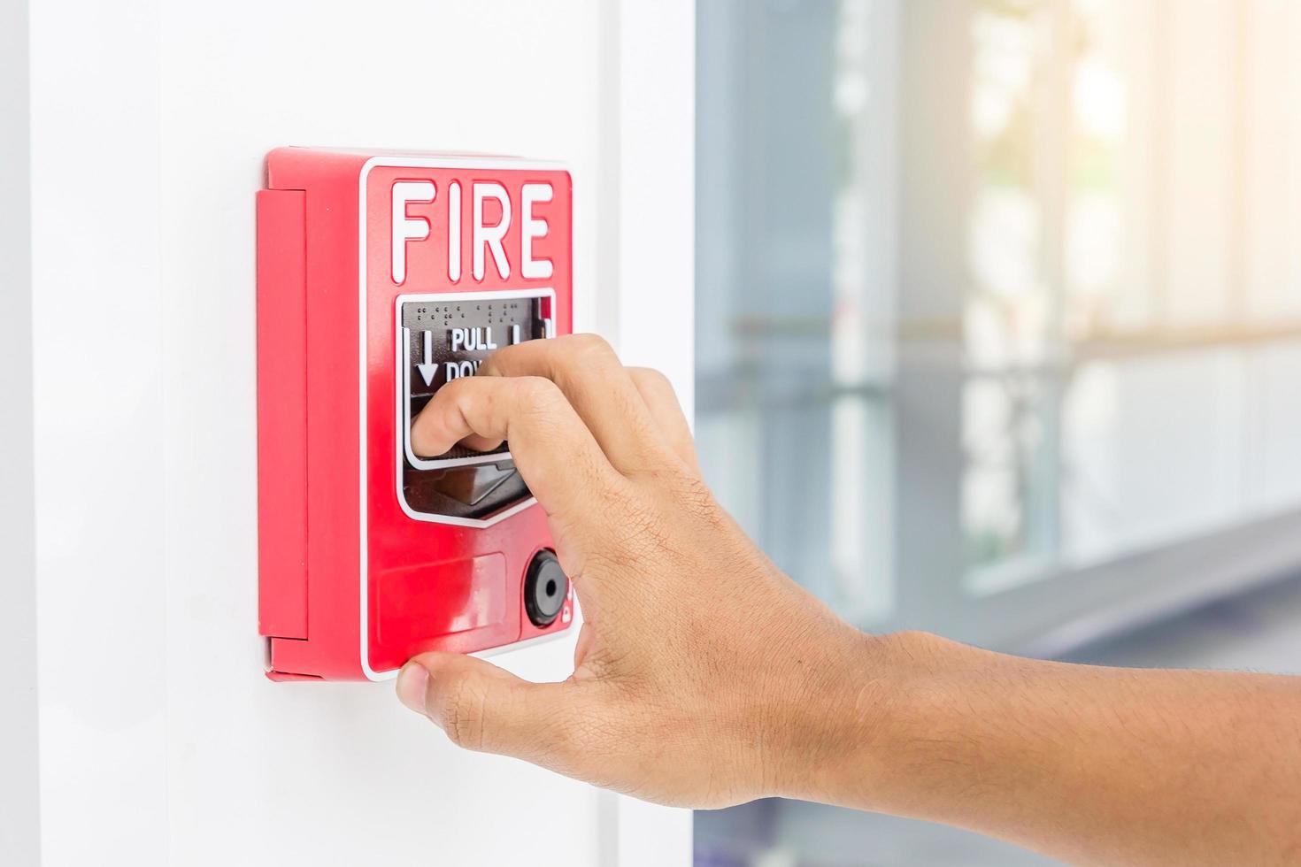 hand van de mens die brandalarmschakelaar trekt foto