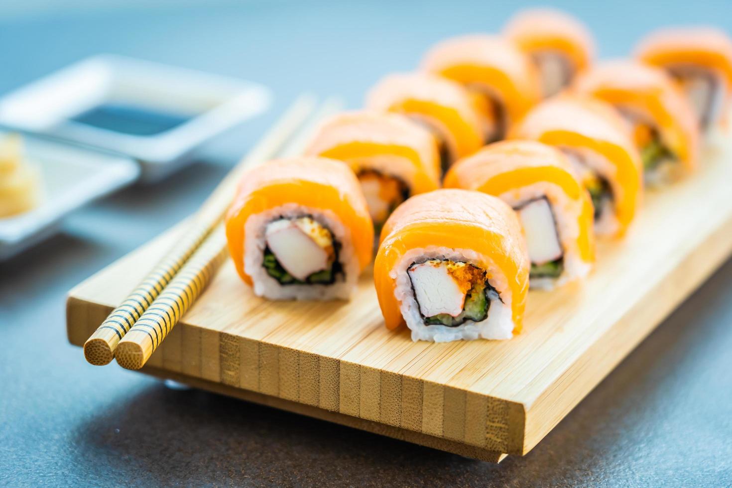 zalmsushi rolt op houten plaat foto