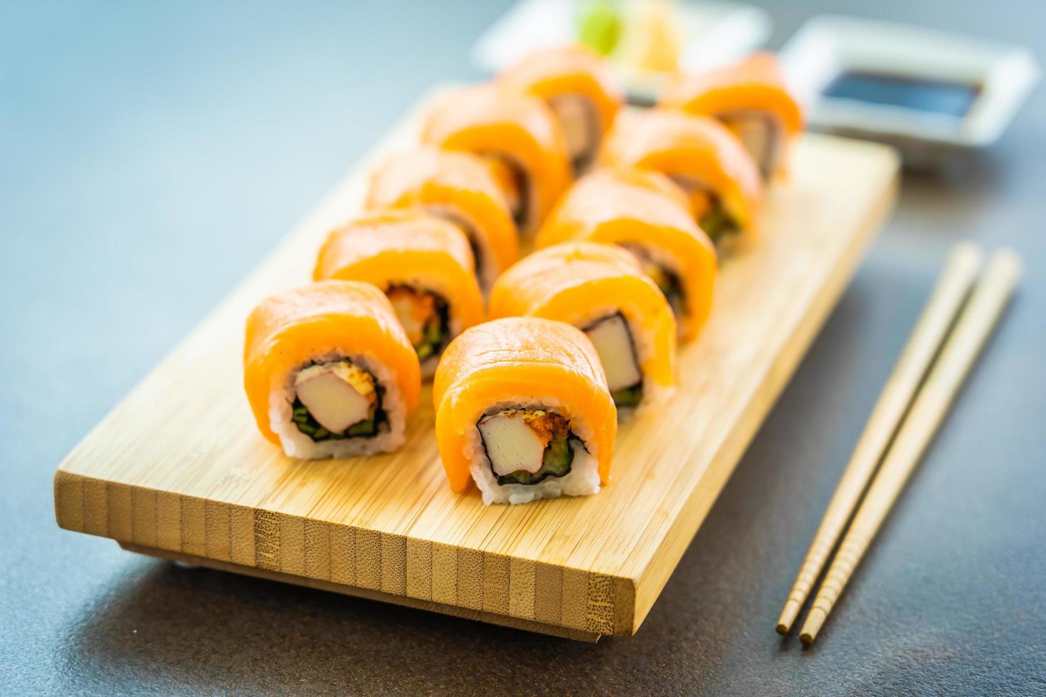 zalmsushi rolt op houten plaat foto