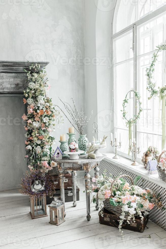 elegant helder interieur van de leven kamer, versierd voor Pasen. haard met bloemen. er is Nee een in de kamer. foto