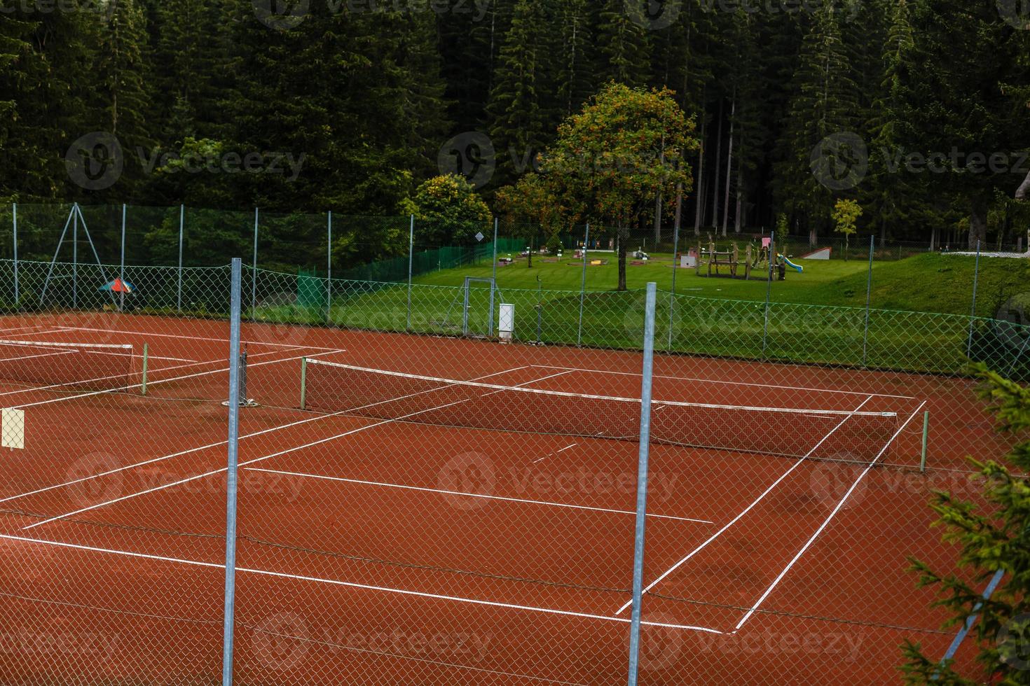 tennis rechtbank en omringd door bomen en heuvels. de perfect plaats voor ontspanning en oefening voor een mooi zo Gezondheid foto