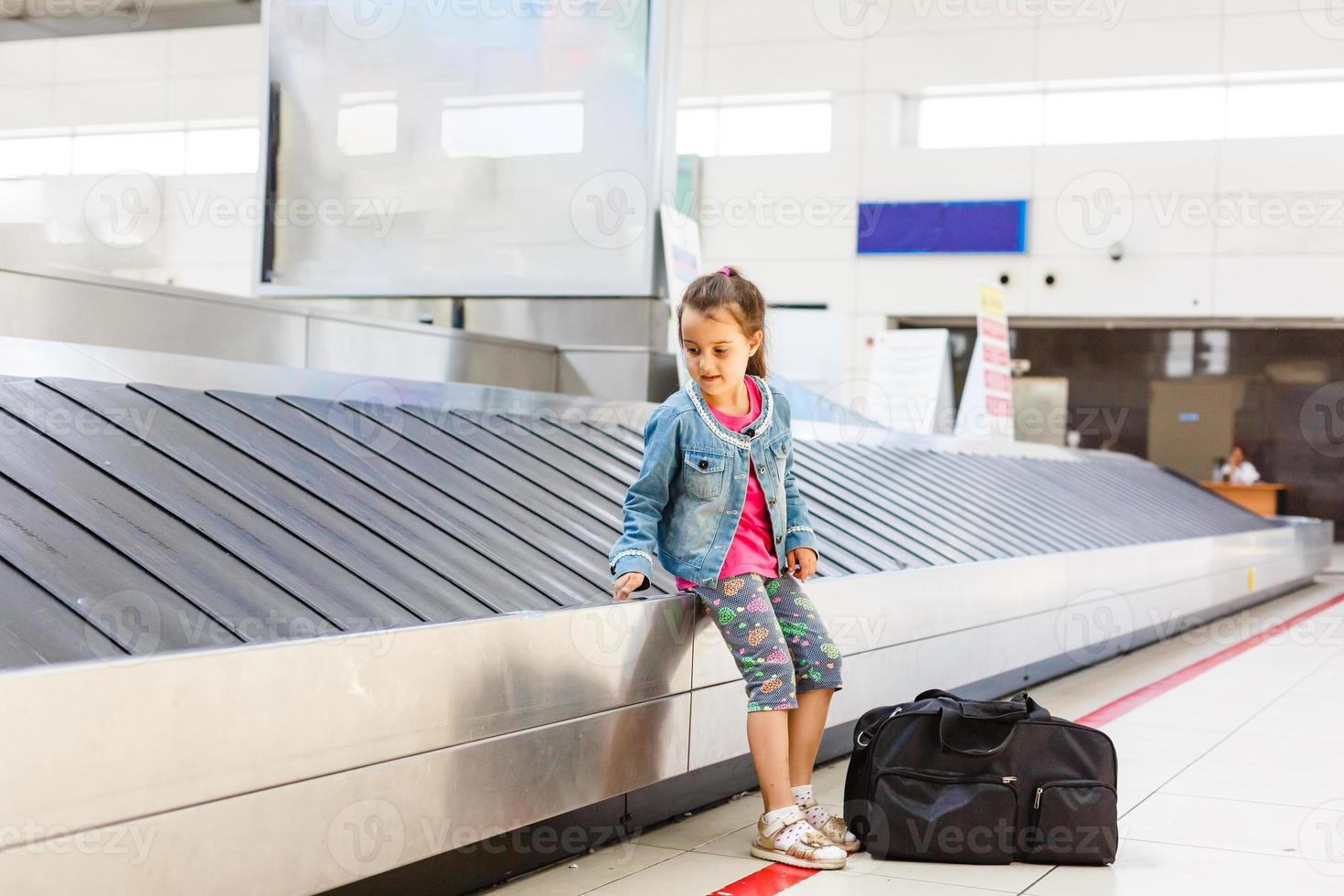 weinig meisje Bij de luchthaven in de buurt de bagage beweren ontvangen bagage foto