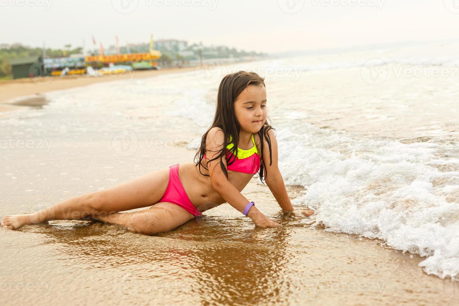 gelukkig meisje Aan een tropisch strand oceaan heeft een pret met plons foto