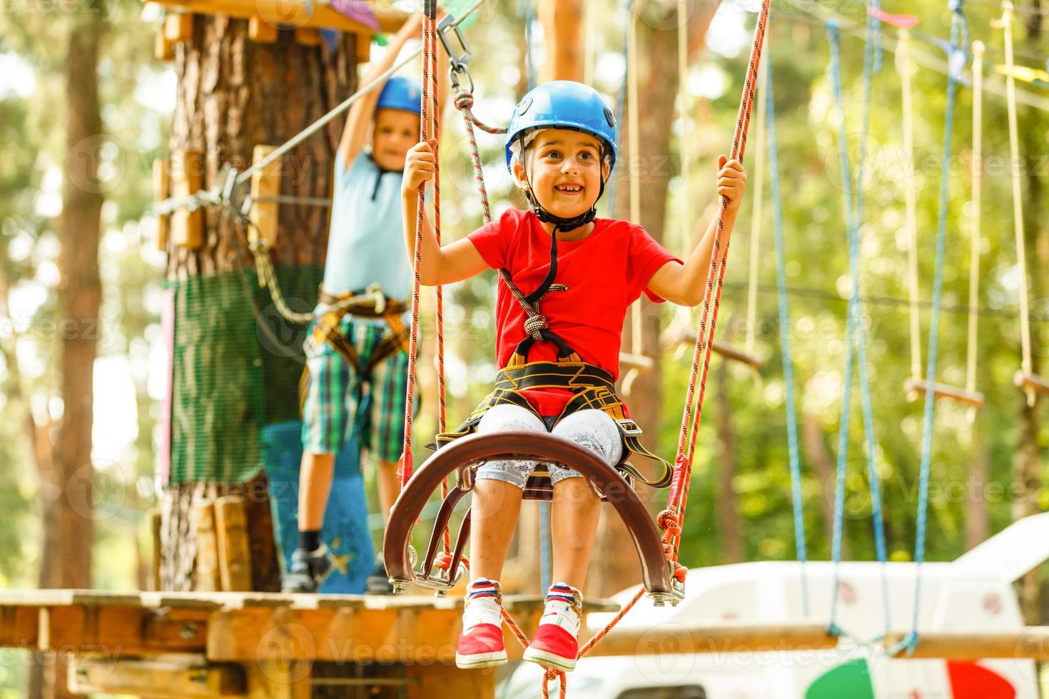 kinderen - een jongen en een meisje in de touw park voorbij gaan aan obstakels. broer en zus beklimmen de touw weg foto