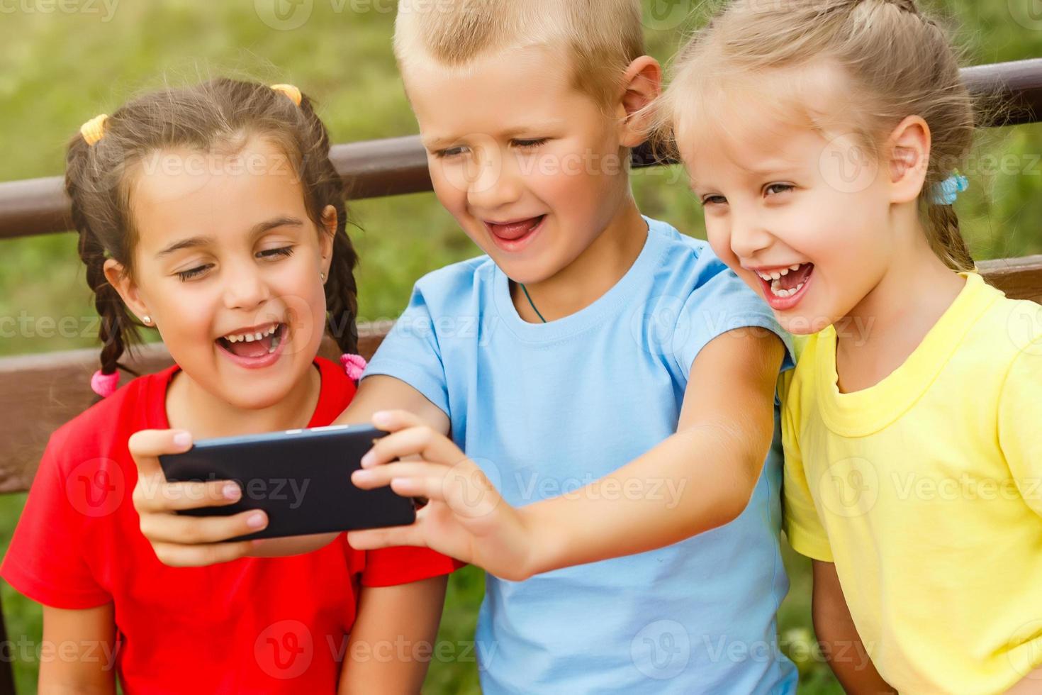gelukkig kinderen nemen een selfie met slim telefoon. thema's vriendschap, zomertine en modern technologie foto