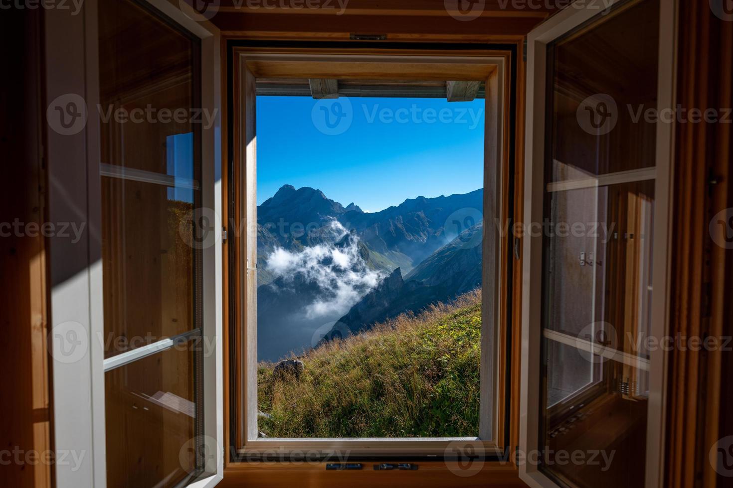 een berg landschap gefotografeerd van een huis, de venster vormen de kader van de beeld foto
