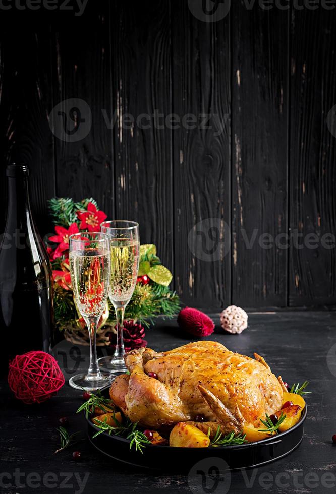 gebakken kalkoen of kip. de Kerstmis tafel is geserveerd met een kalkoen, versierd met helder klatergoud. gebakken kip, tafel instelling. Kerstmis diner. foto