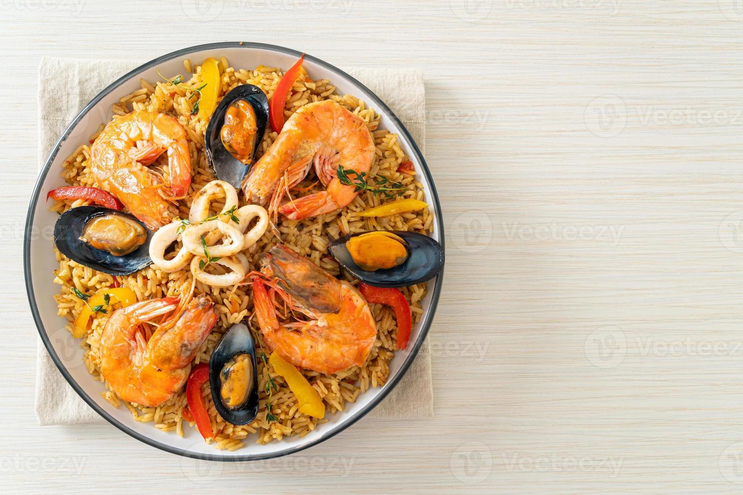 zeevruchtenpaella met garnalen, kokkels, mosselen op saffraanrijst foto