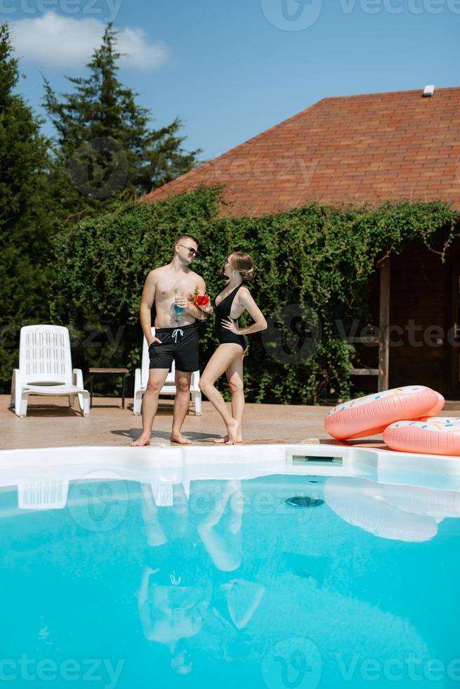 vent en een meisje in het baden pakken zijn ontspannend, in de buurt de blauw zwembad foto