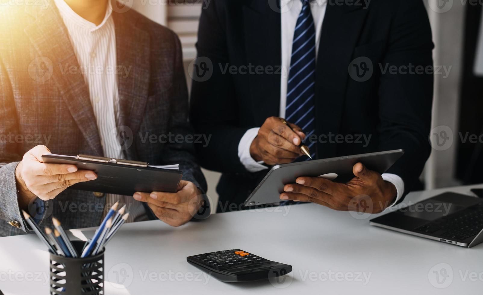 financiële analisten analyseren zakelijke financiële rapporten over een investeringsproject voor digitale tabletplanning tijdens een discussie op een bijeenkomst van bedrijven die de resultaten van hun succesvolle teamwerk laten zien. foto