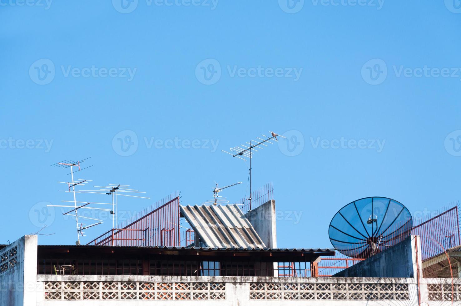 satelliet schotel en televisie antenne Aan de oud gebouw met de blauw lucht achtergrond in de ochtend- foto