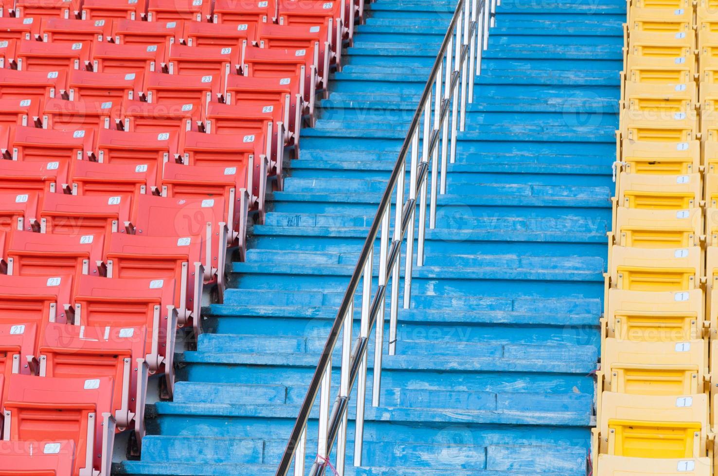 leeg oranje en geel stoelen Bij stadion, rijen loopbrug van stoel Aan een voetbal stadion foto