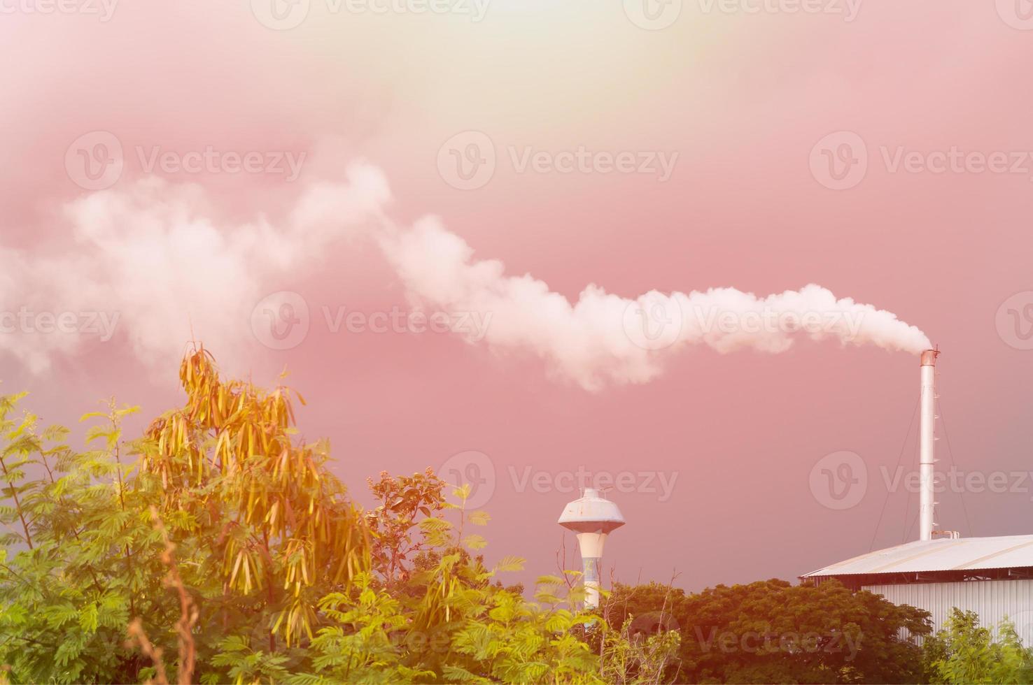 reusachtig fabriek schoorsteen vervuilend de lucht, hoog schoorsteen emitting water damp en rook vervuiling, industrie veroorzaken verontreiniging foto