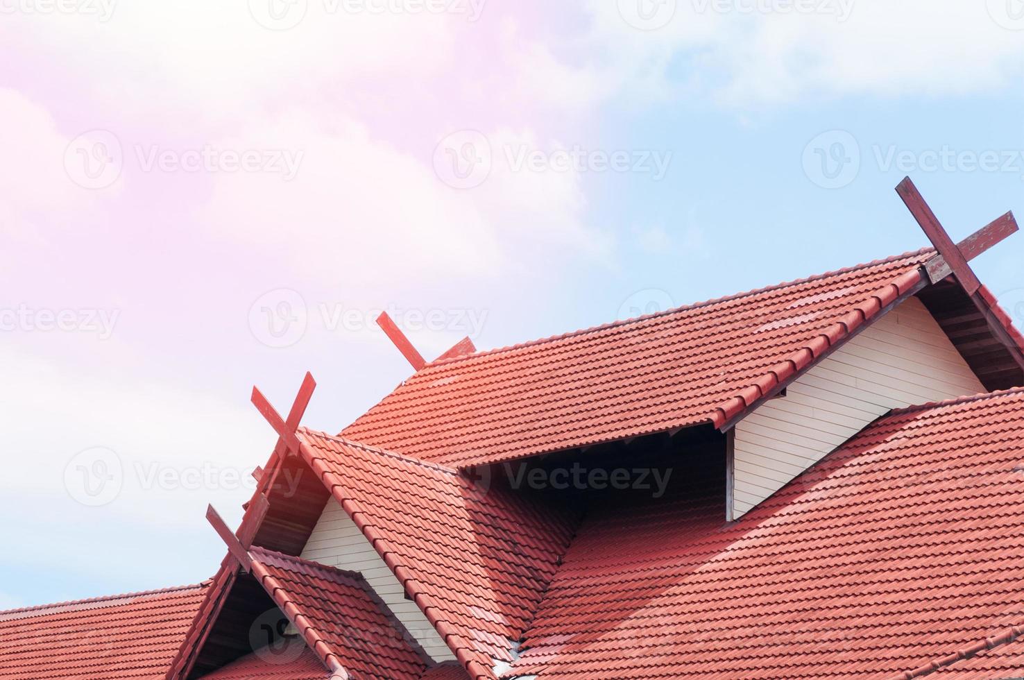 rood dak huis met betegeld dak Aan blauw lucht foto