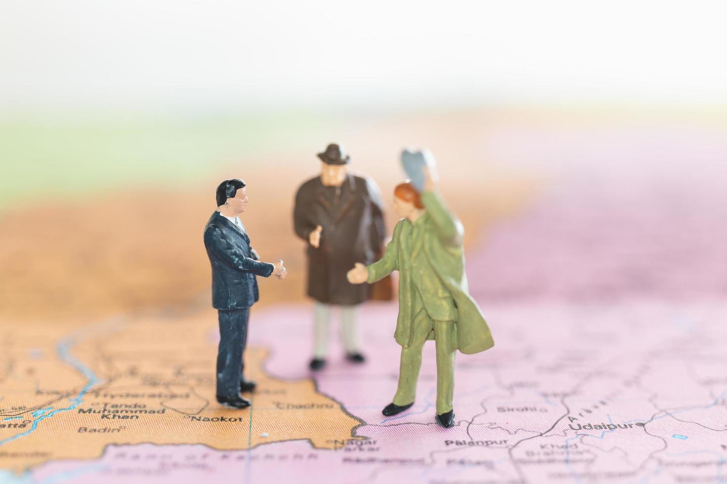 miniatuur toeristen handshaking op een wereldkaart achtergrond, reis en reisconcept foto