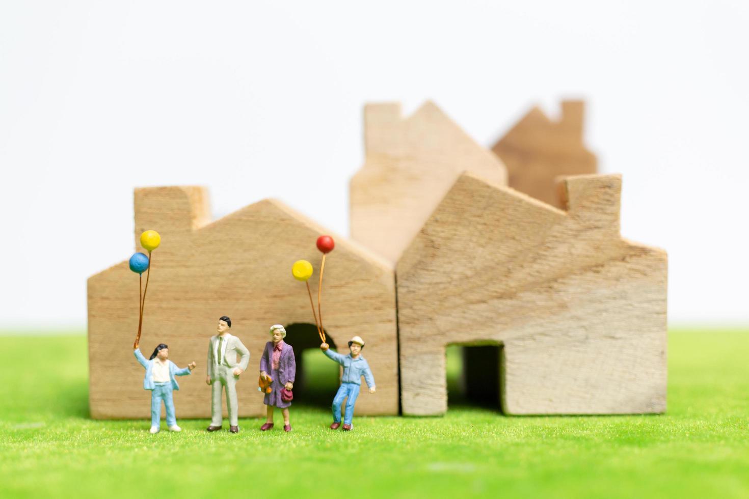 miniatuurfamilie die in een veld met ballons loopt, het concept van de gelukkige familietijd foto