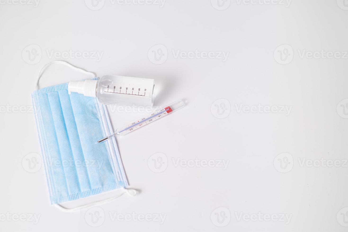 chirurgisch masker met thermometer en desinfecterende gel foto