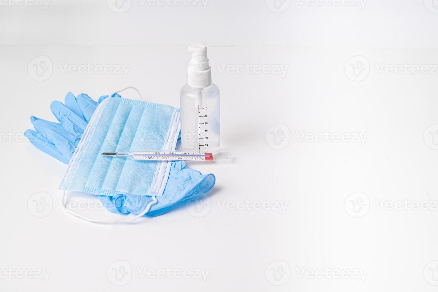 nitrilhandschoenen met chirurgisch masker van hydroalcoholische gel en thermometer foto