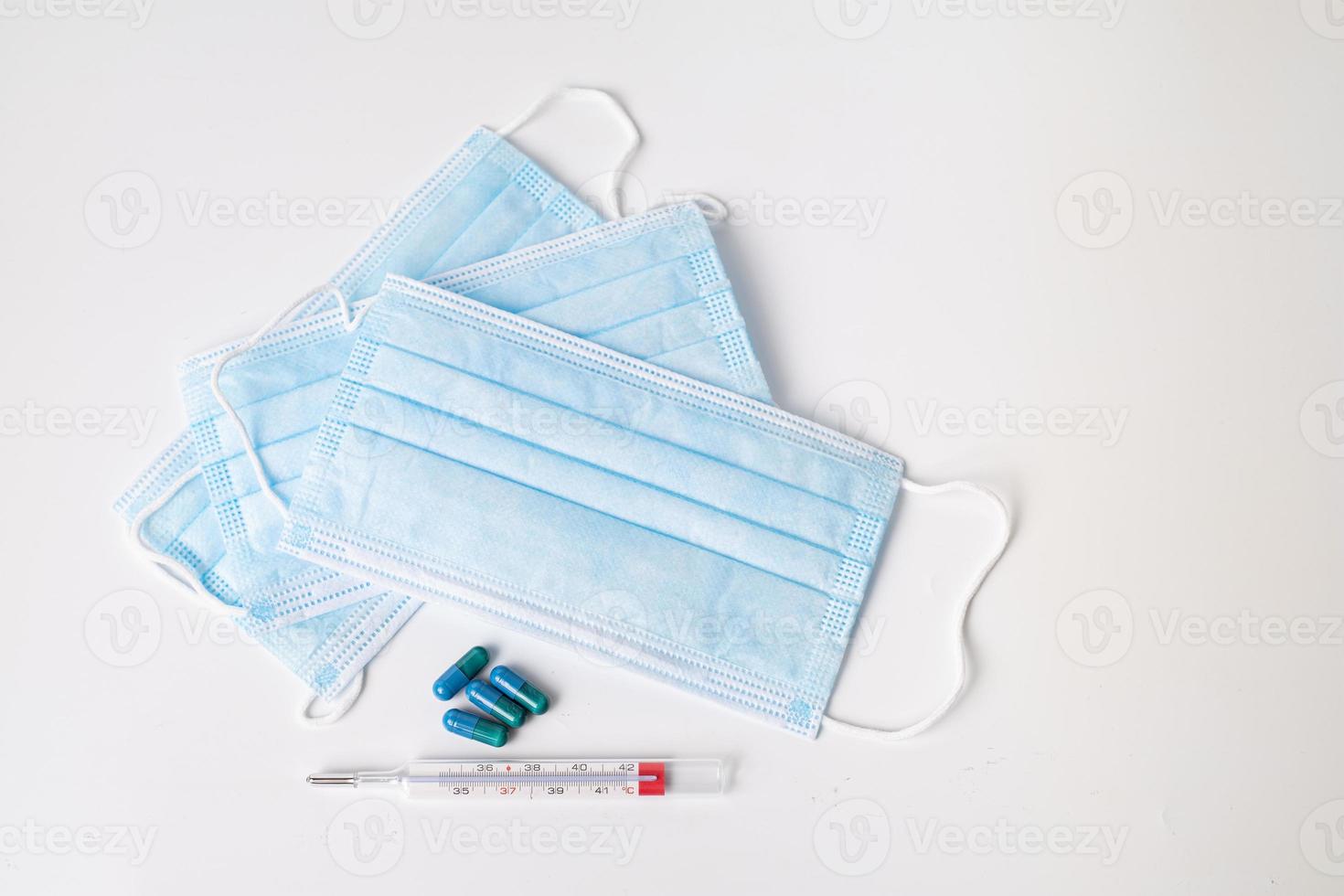 chirurgisch masker, medicinale capsules en thermometer foto