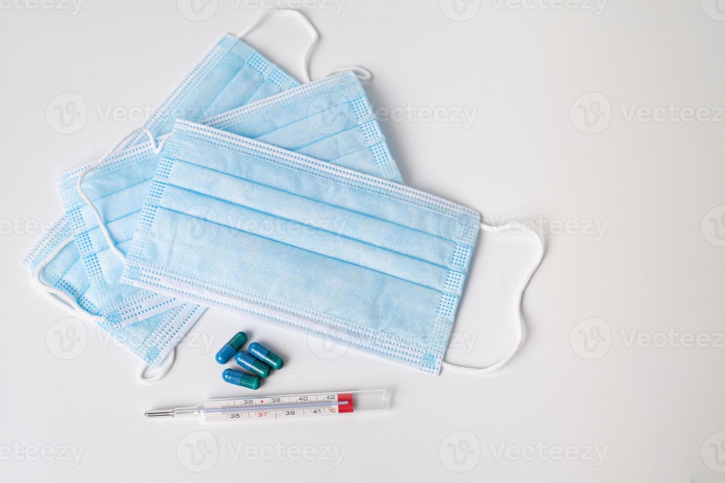 chirurgische masker medicinale capsules en thermometer foto