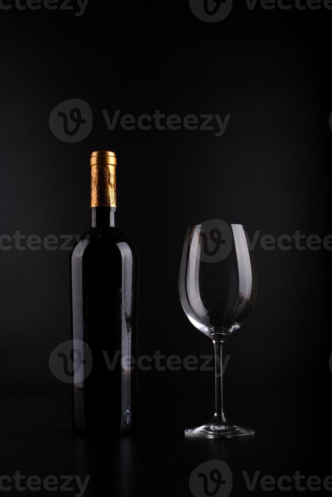 wijnfles en glas met zwarte achtergrond foto