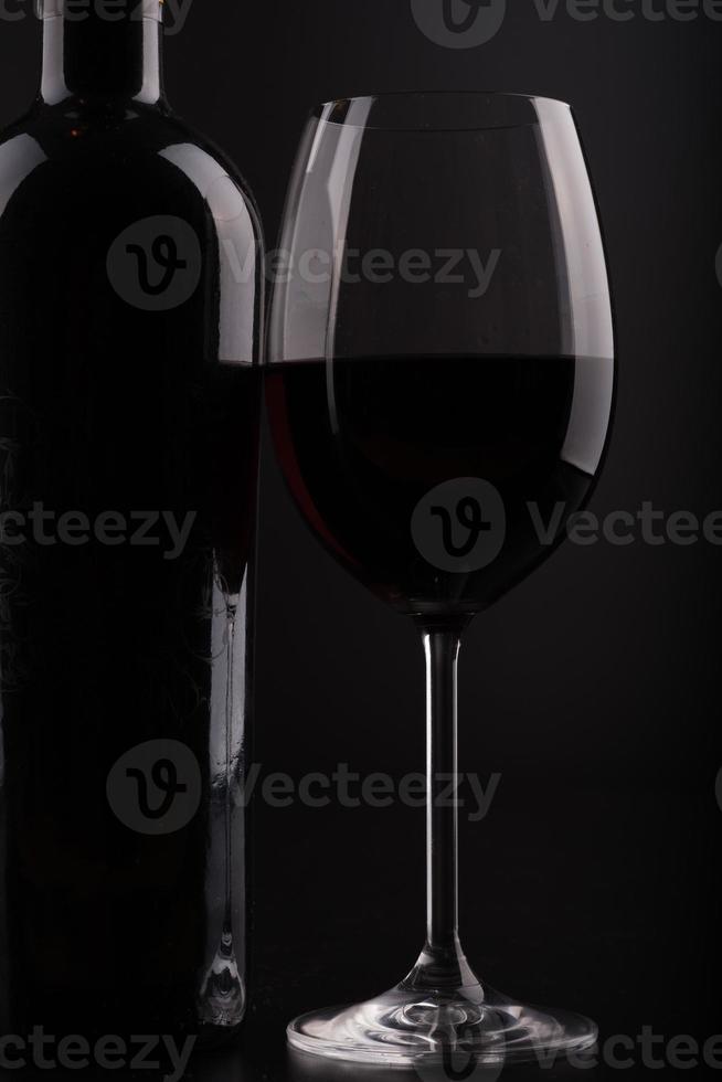 close-up wijnfles en glas met zwarte achtergrond foto