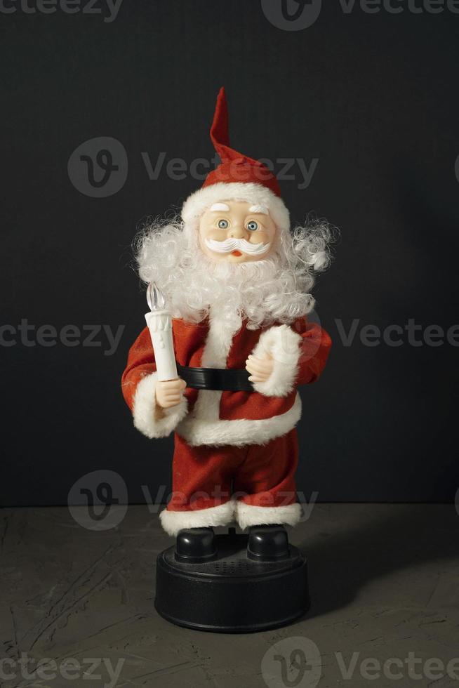 de kerstman claus pop in een rood pak met een kaars foto