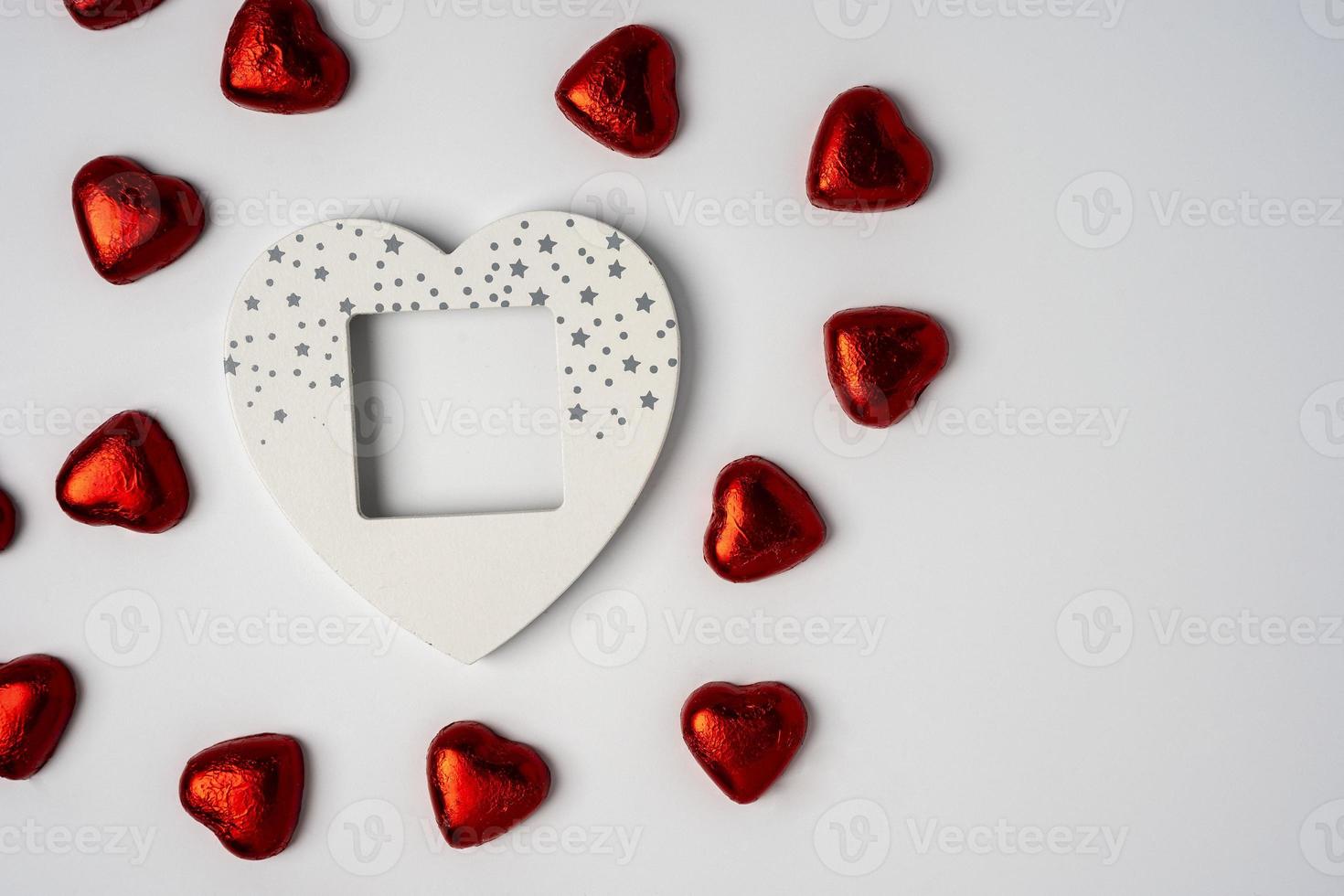 schattig houten gekleurde leeg hartvormig foto kader en veel van glimmend hartvormig snoepjes
