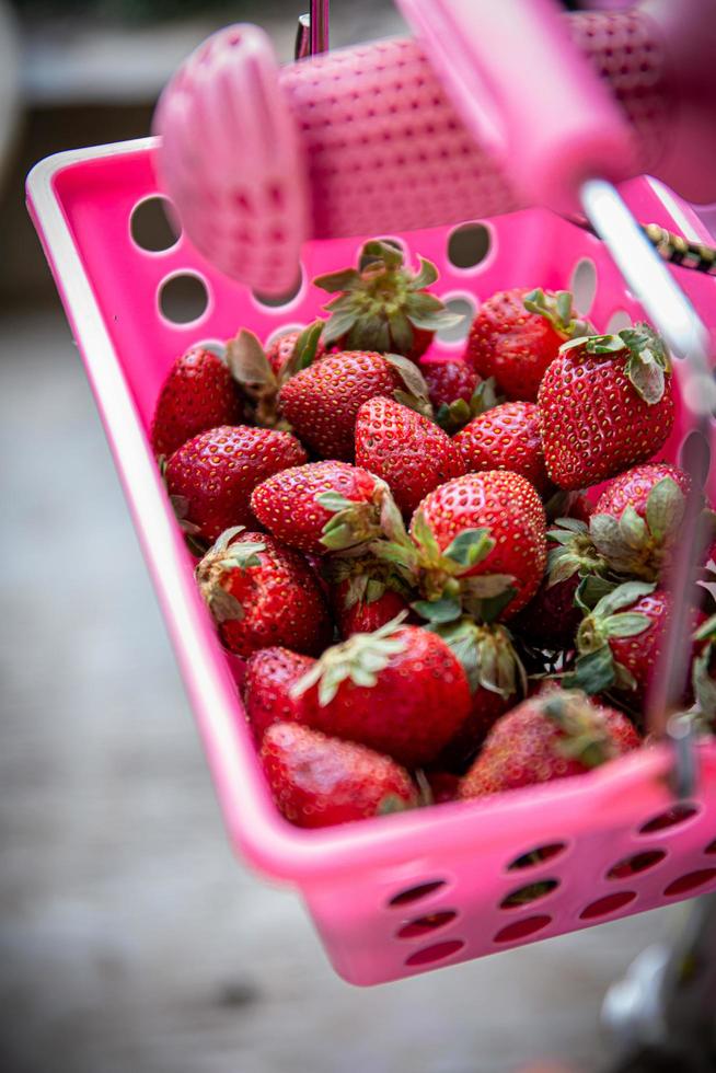 aardbeien in een roze mand foto
