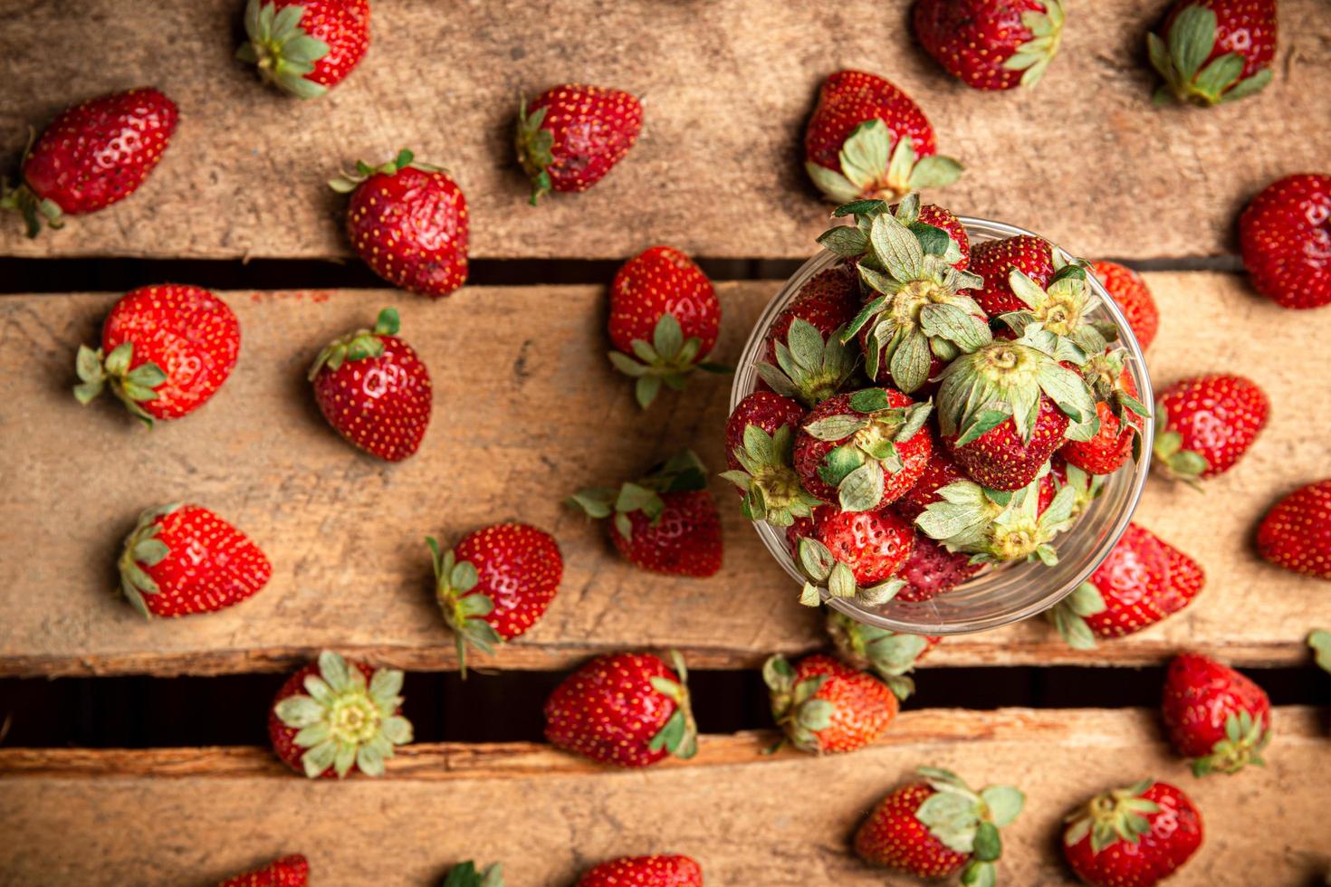 aardbeien in een glas en op een tafel foto