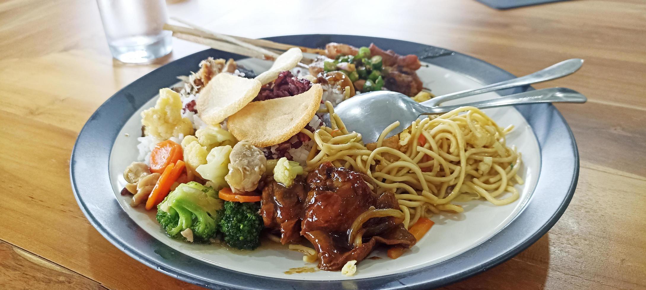 rijst- schotel met kant gerechten van kip, bloemkool, broccoli, noedels en crackers in een bord foto